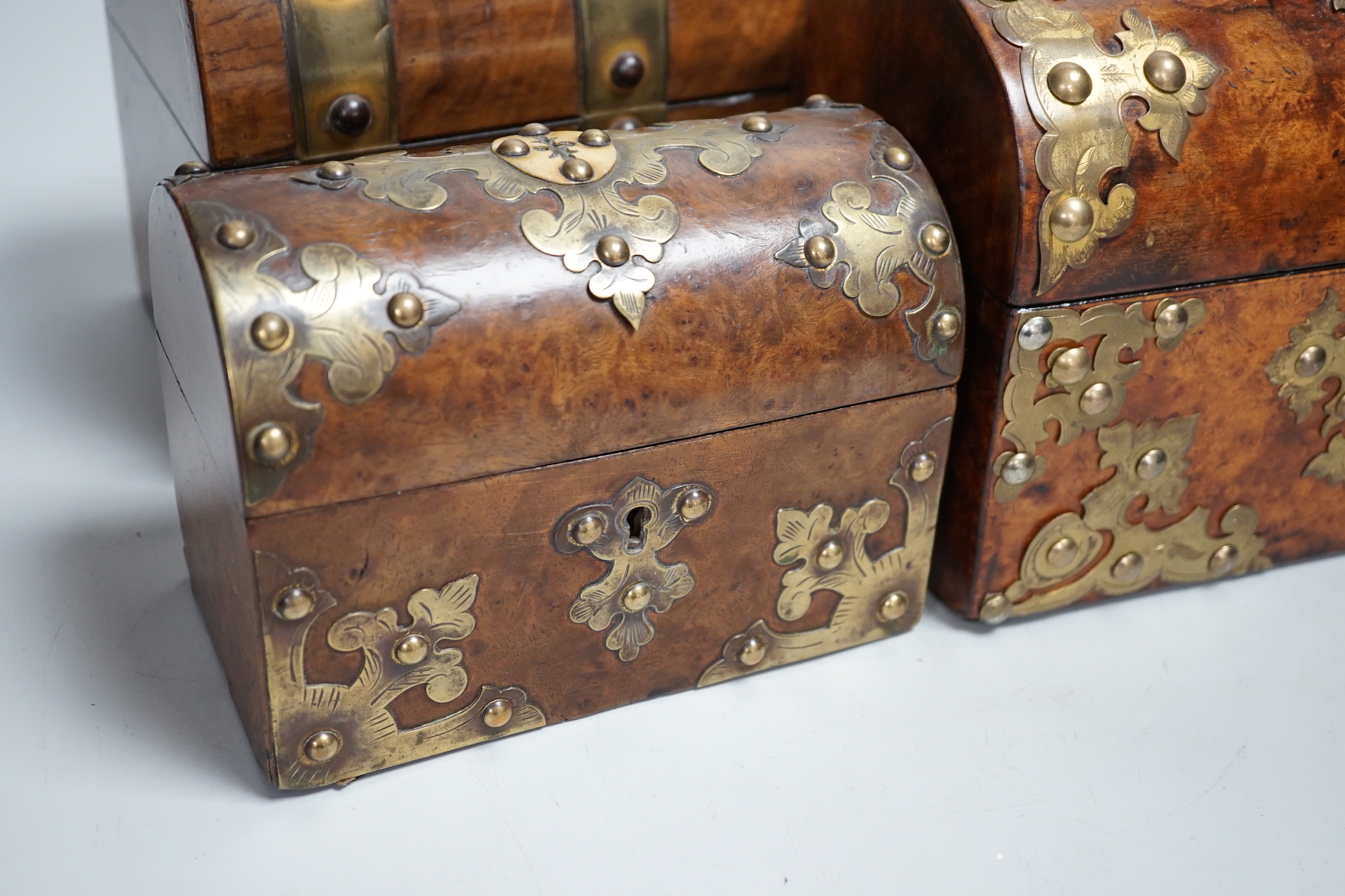 Three Victorian walnut domed topped and brass mounted caskets, largest 23cm wide x 17cm high